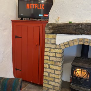 Gemütliche Sitzecke mit Fernseher und Holzofen