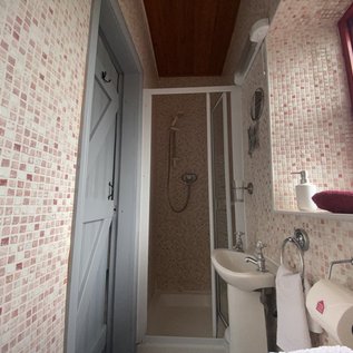 Badezimmer mit Dusche, Waschbecken und WC