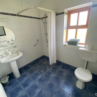 Badezimmer mit Dusche, Waschbecken und WC